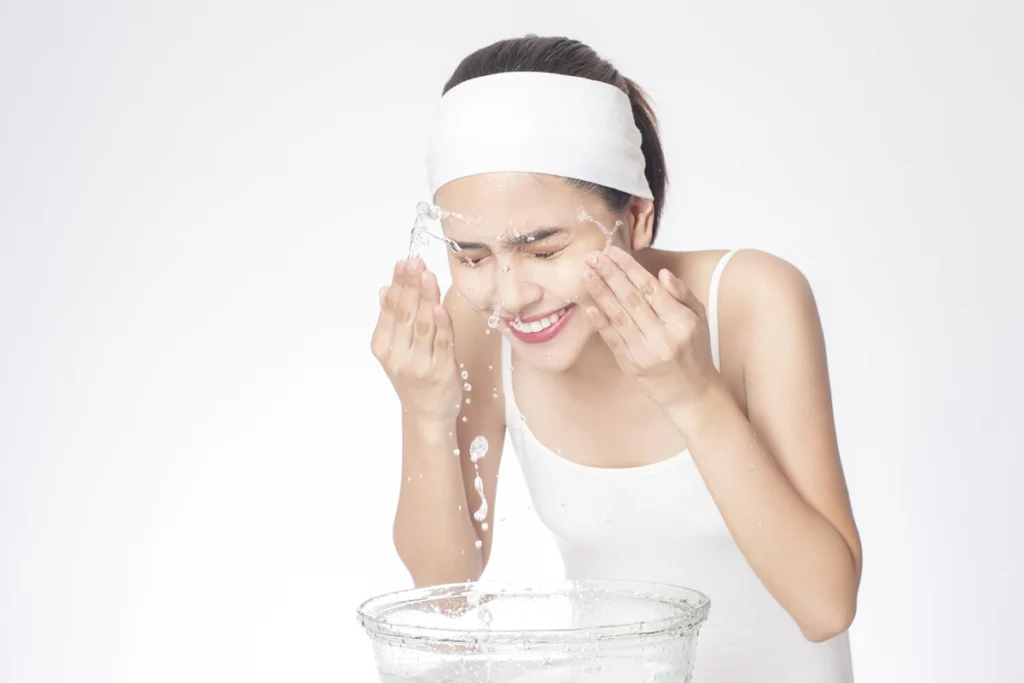 beautiful woman is washing her face white background